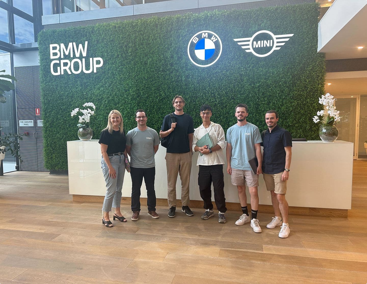 The Inlight team standing in front of the front desk at the BMW office