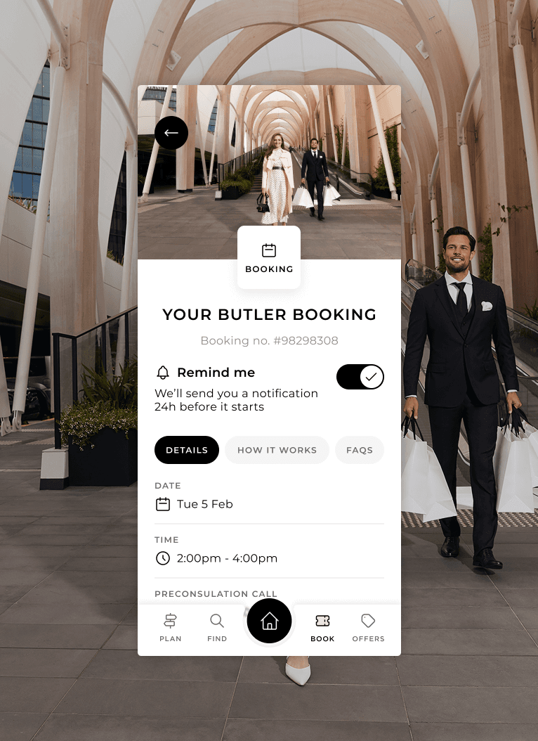 A mobile app booking screen over a backdrop of an outdoor shopping precinct with arched walkways. The booking details show a butler service reservation, notification reminder toggle, date, time, and information tabs.